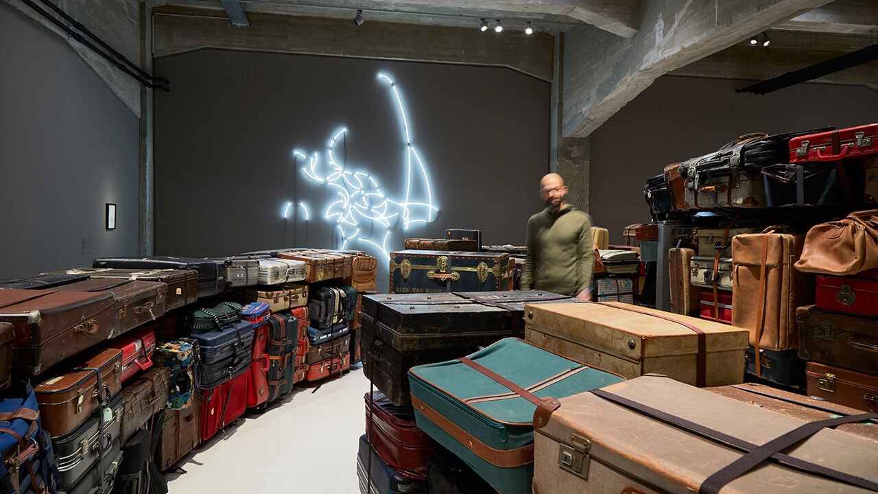 A man looks at a display of suitcases in the Fenix Museum in Rotterdam, Netherlands